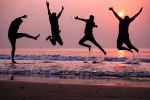 photo of people doing jump shot on beach